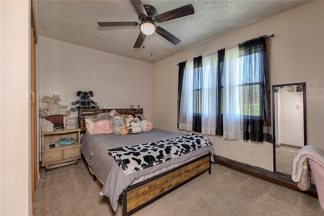 bedroom featuring carpet, a textured ceiling, and a ceiling fan