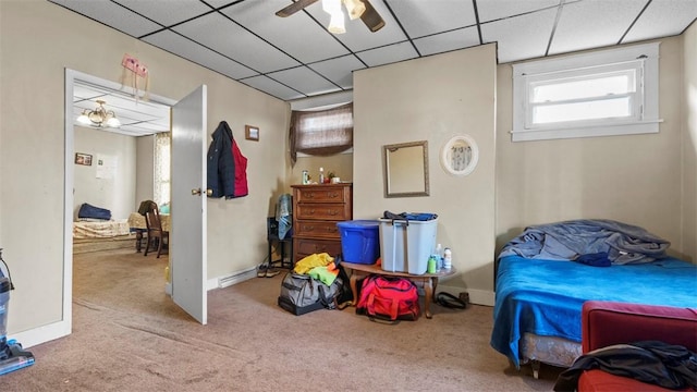carpeted bedroom with baseboards and a drop ceiling