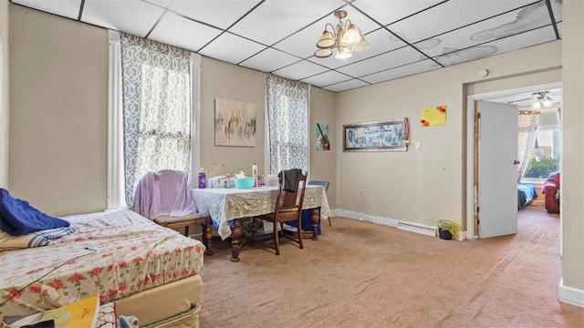 carpeted bedroom featuring a paneled ceiling and baseboards