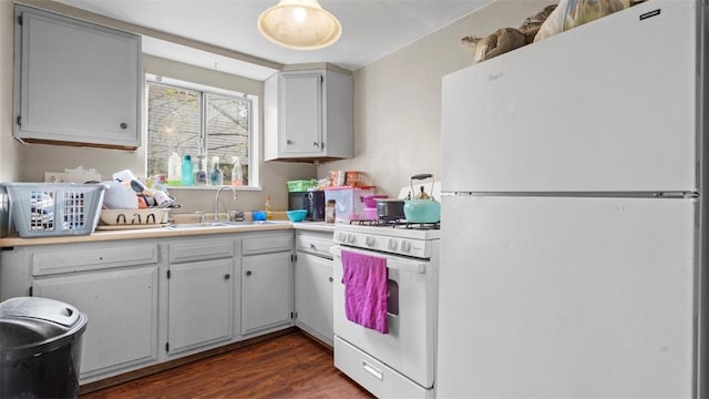 kitchen with a sink, light countertops, white appliances, dark wood finished floors, and white cabinetry