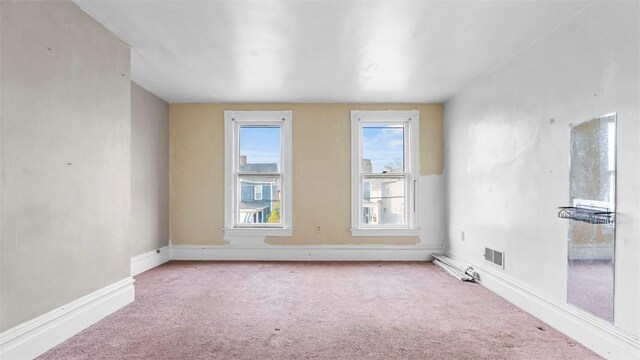 carpeted spare room featuring baseboards and visible vents