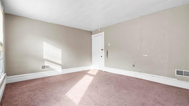 carpeted spare room with visible vents and baseboards