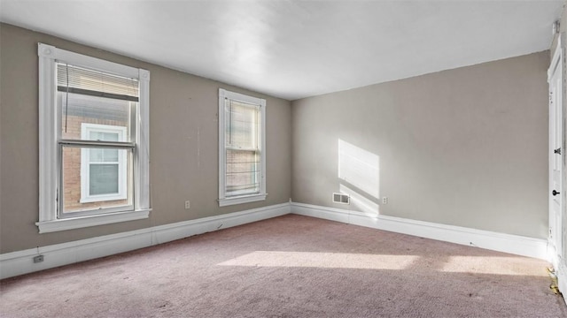 carpeted empty room with baseboards and visible vents