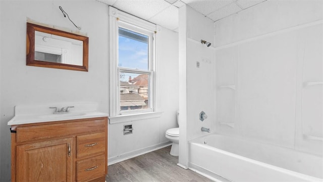 bathroom with vanity, a paneled ceiling, plenty of natural light, toilet, and wood finished floors