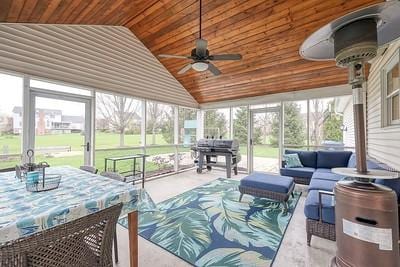 sunroom featuring ceiling fan and an outdoor living space