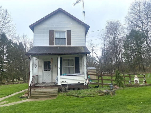 view of front of property with a porch, a front lawn, fence, and a shingled roof