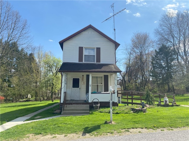 view of front facade with a porch, a front lawn, and fence