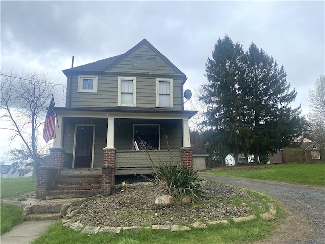 view of front facade featuring driveway, a porch, and a garage