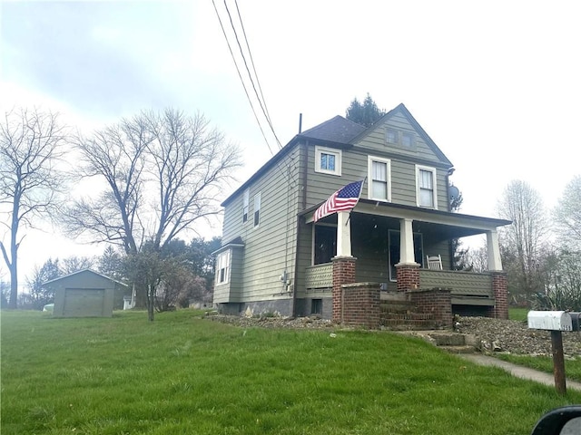 view of front facade with an outbuilding, a front lawn, and covered porch