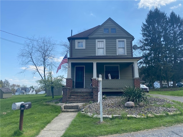 view of front facade featuring brick siding, a front yard, and covered porch
