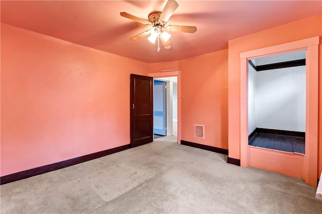 empty room with visible vents, baseboards, a ceiling fan, and carpet floors