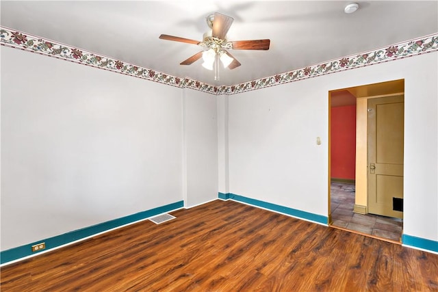 unfurnished room with visible vents, baseboards, a ceiling fan, and wood finished floors