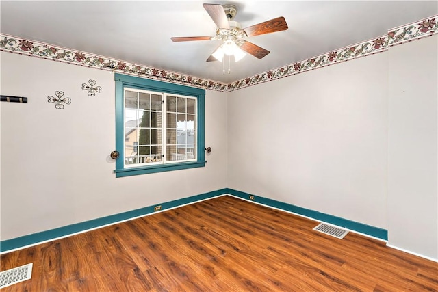 spare room featuring visible vents, baseboards, and wood finished floors