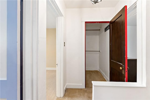 hall with baseboards and carpet