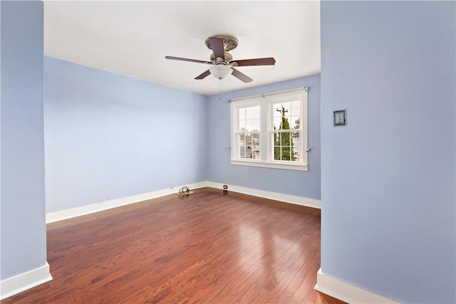 empty room with dark wood-style flooring, ceiling fan, and baseboards
