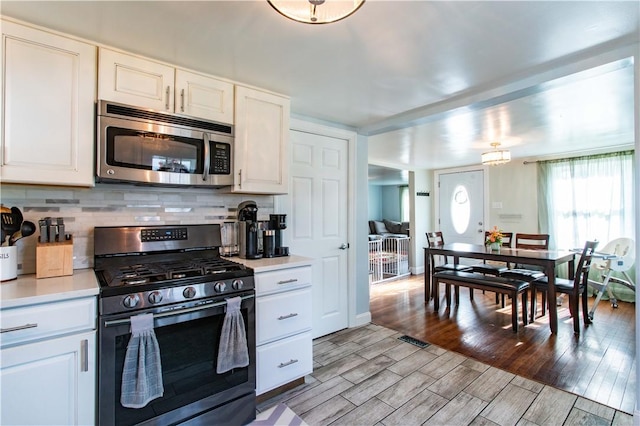 429 Big Knob Rd, New Sewickley Twp, PA 15074 - kitchen featuring backsplash, light countertops, light wood-style floors, and stainless steel appliances