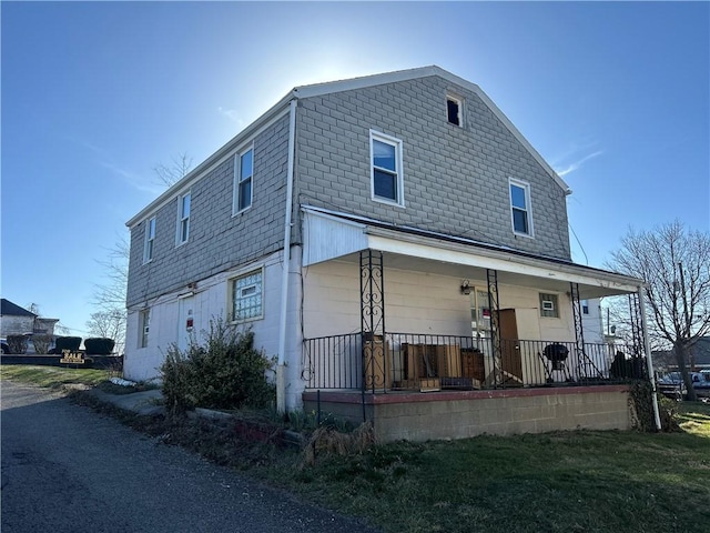 exterior space with covered porch and concrete block siding