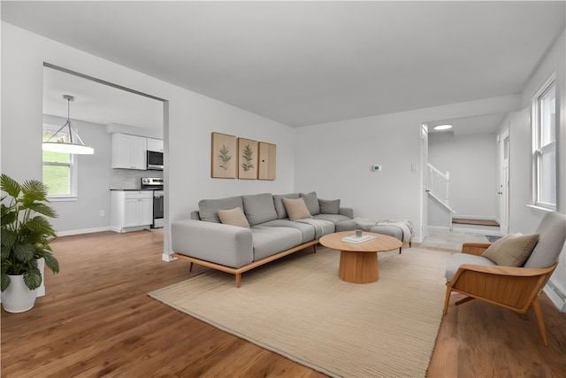 1226 Lamson Cir, Upper St Clair, PA 15241 - living room featuring light wood-style flooring, baseboards, and stairs