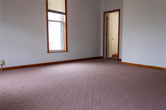 carpeted spare room with baseboards