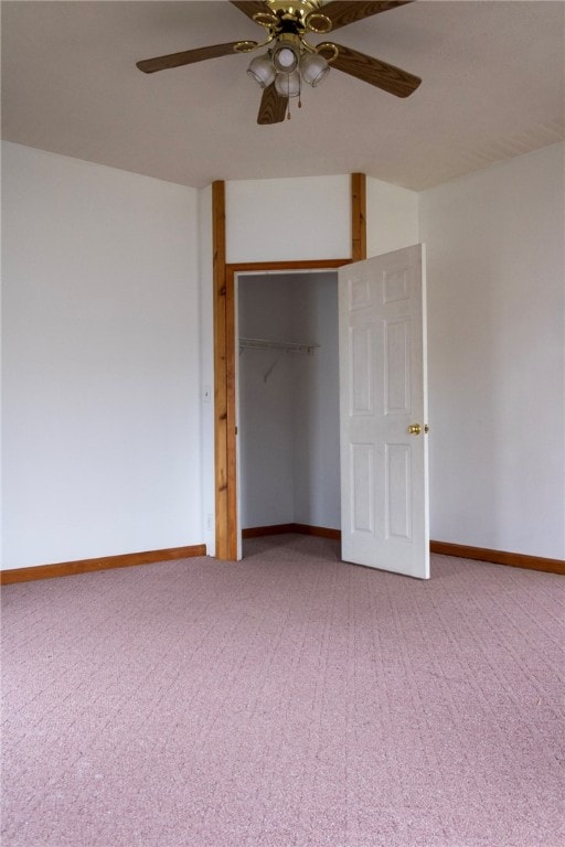 unfurnished bedroom featuring ceiling fan, a closet, light colored carpet, and baseboards