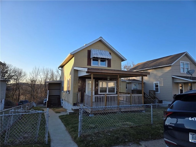 view of front of house with a front yard, a porch, a gate, and a fenced front yard
