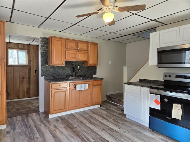 kitchen with a drop ceiling, a sink, a ceiling fan, and appliances with stainless steel finishes