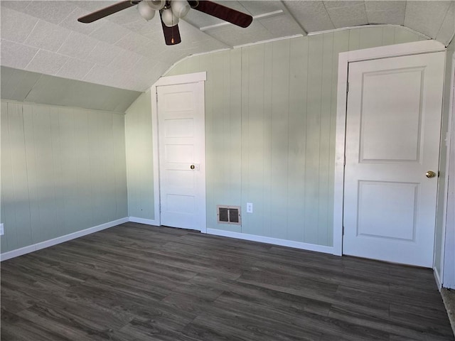 empty room with dark wood finished floors, ceiling fan, lofted ceiling, and visible vents