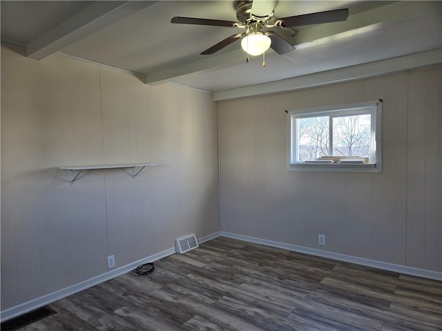 spare room featuring wood finished floors, beamed ceiling, ceiling fan, and visible vents