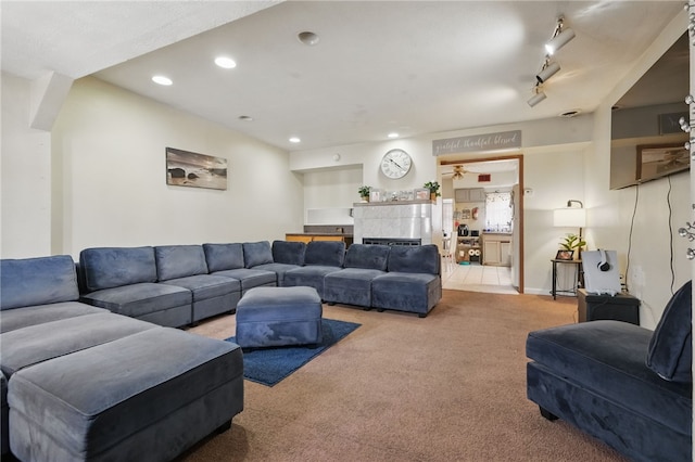 living area with recessed lighting, carpet, and a tiled fireplace