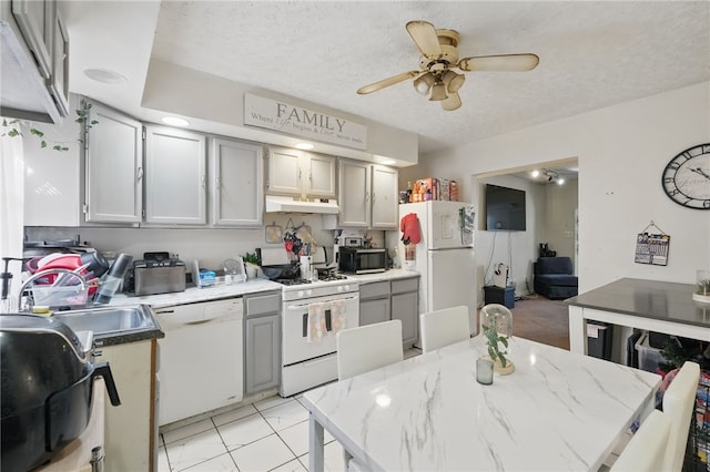 kitchen with ceiling fan, white appliances, under cabinet range hood, a sink, and gray cabinetry