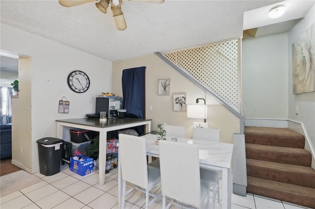 dining space with baseboards, a ceiling fan, tile patterned flooring, and stairs