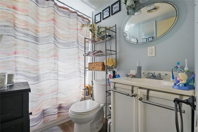 full bathroom with toilet, vanity, and wood finished floors