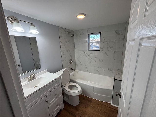 bathroom with toilet, wood finished floors, vanity, and tub / shower combination