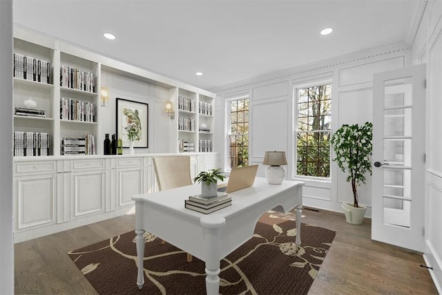 home office featuring built in features, a decorative wall, recessed lighting, and wood finished floors