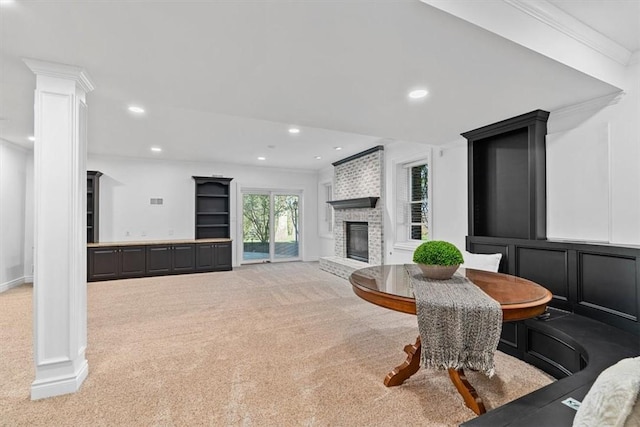 living area featuring ornamental molding, decorative columns, a brick fireplace, recessed lighting, and carpet flooring