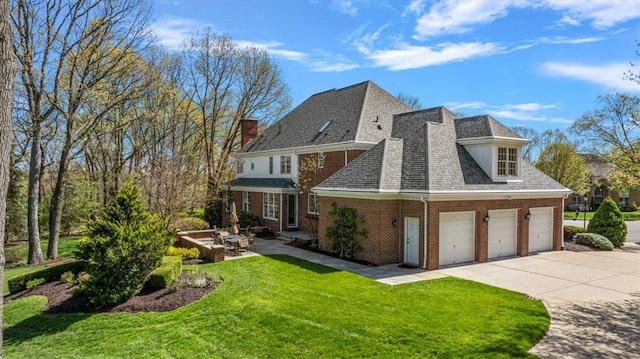 exterior space with a chimney, a lawn, brick siding, concrete driveway, and a shingled roof