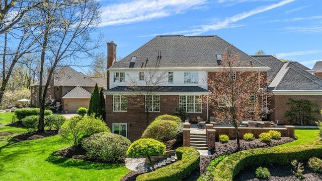 back of property featuring stairs, brick siding, a garage, a chimney, and a lawn
