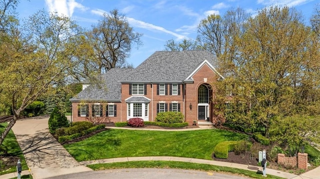 view of front of house featuring a front yard and brick siding