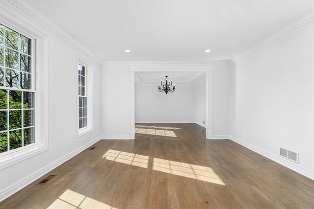 unfurnished room with baseboards, an inviting chandelier, wood finished floors, and visible vents