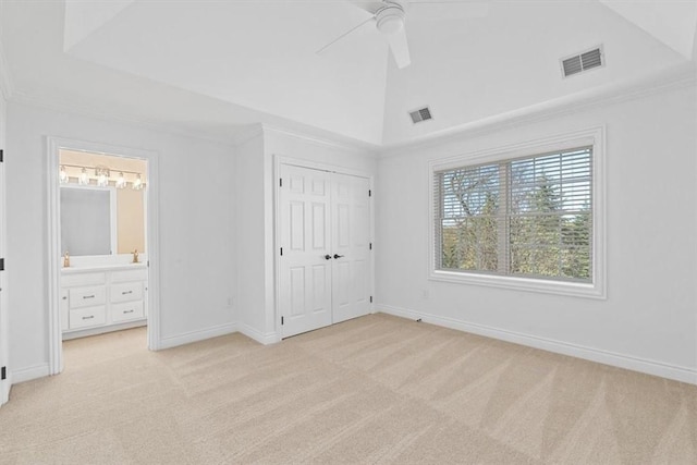 unfurnished bedroom featuring light colored carpet, ensuite bathroom, and visible vents