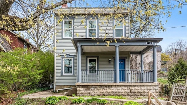 rear view of property with a porch and a chimney