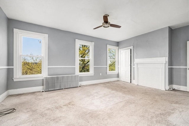 unfurnished bedroom featuring radiator heating unit, carpet flooring, ceiling fan, and baseboards