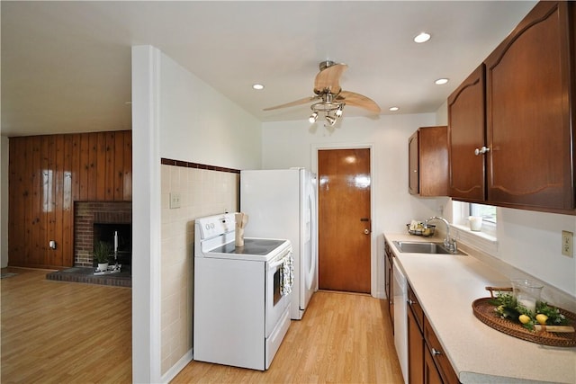 kitchen with a sink, light countertops, a ceiling fan, white appliances, and light wood-style flooring