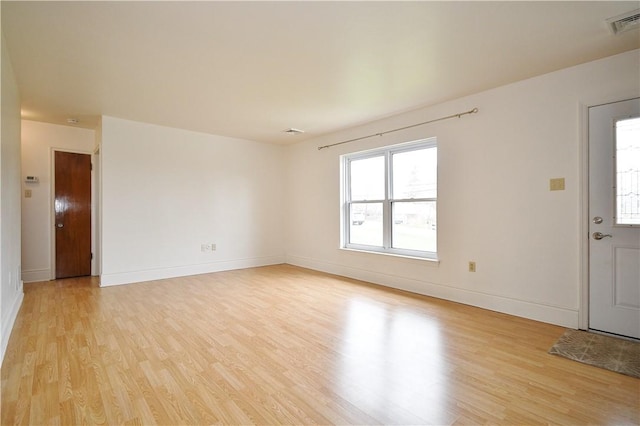 interior space with light wood-style floors, baseboards, and visible vents