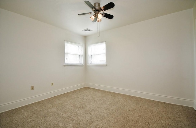empty room featuring visible vents, baseboards, ceiling fan, and light carpet