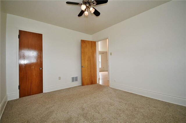 unfurnished bedroom with carpet, visible vents, baseboards, and a ceiling fan