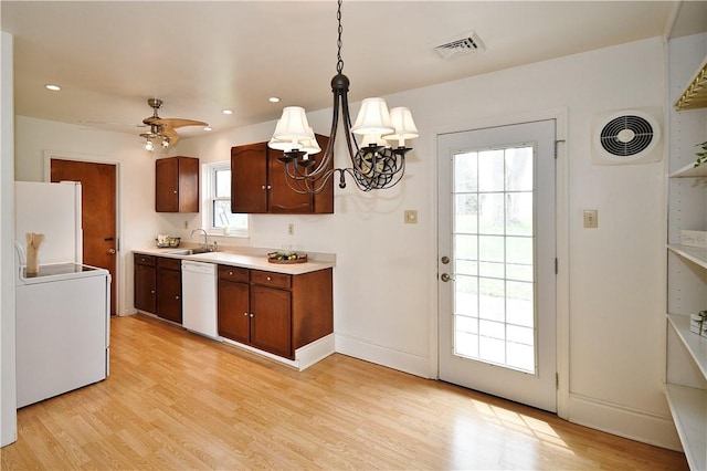 kitchen featuring light countertops, a sink, white appliances, and visible vents