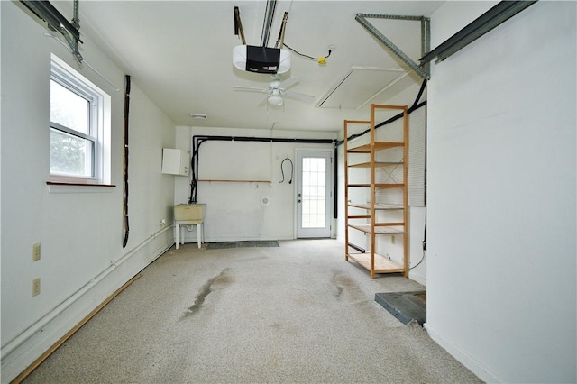 garage featuring a sink, ceiling fan, a garage door opener, and baseboards