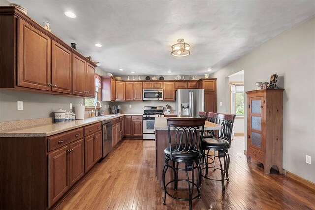 172 Valley Flds, Plum Boro, PA 15239 - kitchen with a sink, light wood-style floors, appliances with stainless steel finishes, and a breakfast bar area