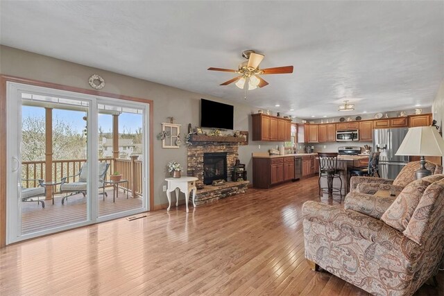 172 Valley Flds, Plum Boro, PA 15239 - living area featuring light wood-style floors, a fireplace, a ceiling fan, visible vents, and baseboards